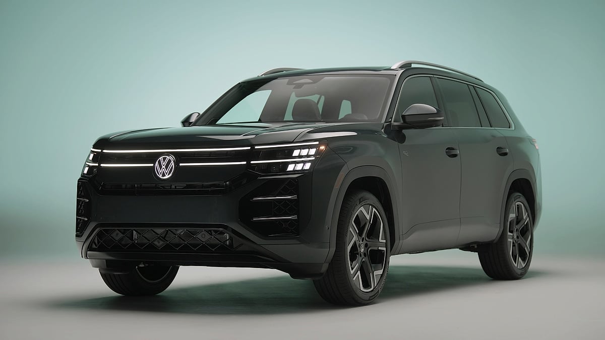 Black Volkswagen Atlas R-Line shown in a studio from the front three-quarter angle with LED lights illuminated.