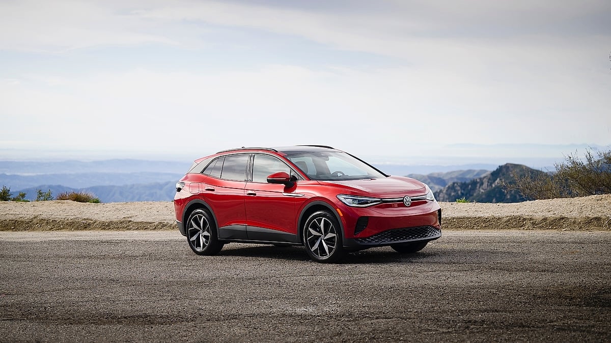 Red Volkswagen ID.4 parked at a mountain overlook, shown from the front three-quarter angle.