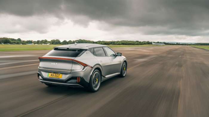 Rear view of the Kia EV6 GT as it drives down a runway.