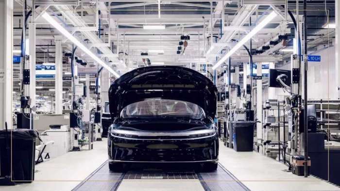 Image showing a black Lucid Air on the AMP-1 production line in the final stages of assembly. The Lucid's frunk is open and we see it from the front.