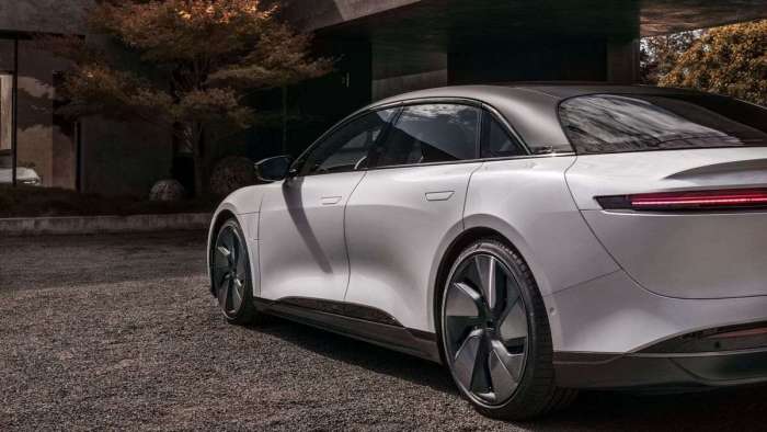 Close-up view of the rear three-quarters of a white Lucid Air equipped with the Stealth Appearance package featuring black roof rails and unique wheels.