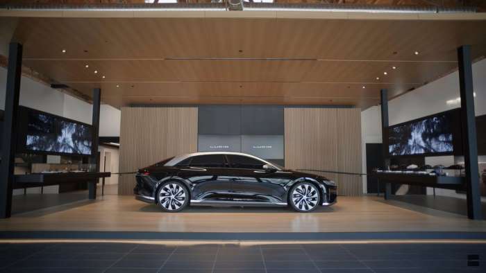 Image of a dark red Lucid Air parked inside the company's flagship Studio in Beverly Hills