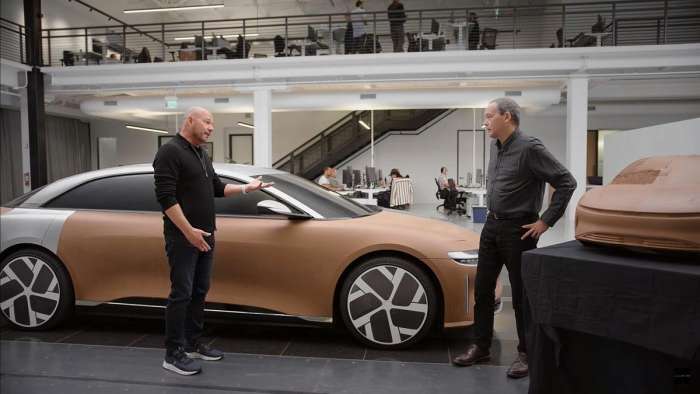 Image of Peter Rawlinson and Derek Jenkins standing beside a full-size clay model of the Lucid Air.