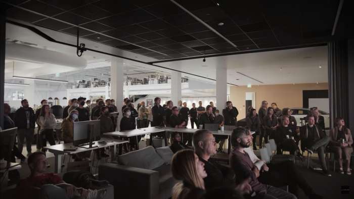 Dozens of Lucid employees are pictured gathered in the studio's presentation space.