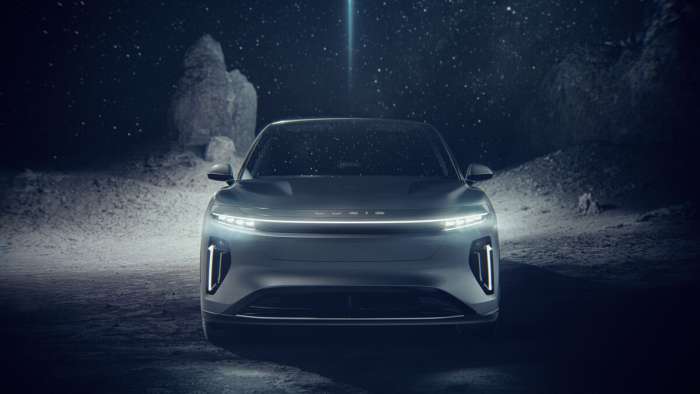 Front-view render of the upcoming Lucid Gravity SUV with its headlights on at night.