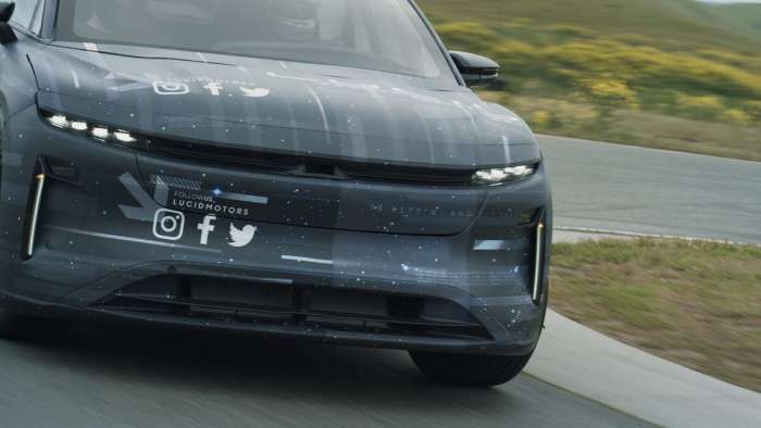 Close-up front view of the camouflaged Lucid Gravity SUV during testing. Its face resembles the Lucid Air though its headlights look further recessed.