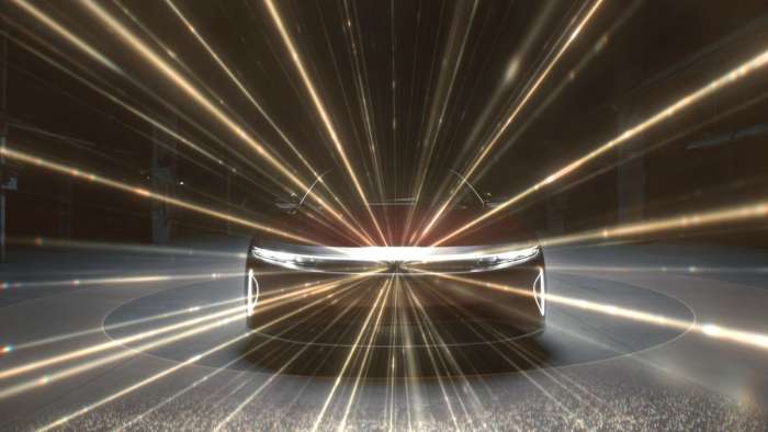 Image showing an artist's impression of the LIDAR system installed in the front of all Lucid Airs. The car's front is pictured with gold beams emanating from the top center of its fascia. 