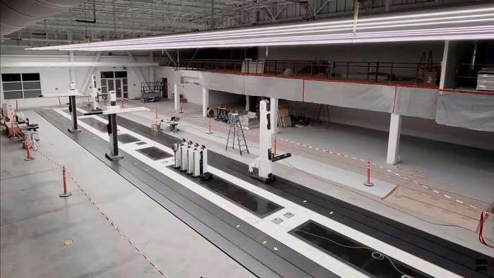 Image from the time lapse of the construction process showing the installation of robotic arms which help in the clay modelling process.