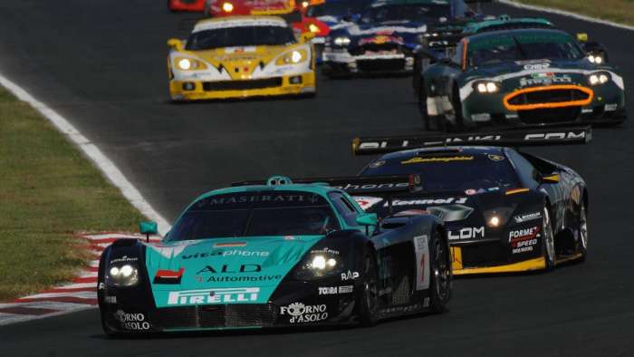 Image showing a black and teal colored Maserati MC12 racing against a Lamborghini Murcielago, Aston Martin DB7 and Chevrolet Corvette.