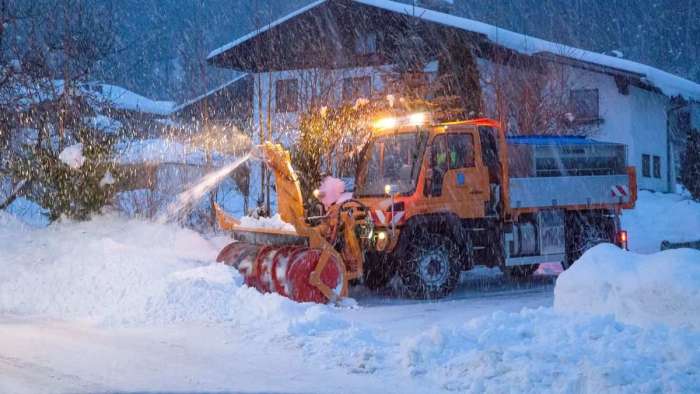 A yellow Mercedes Unimog truck is pictured with a snow blower attachment on the front.