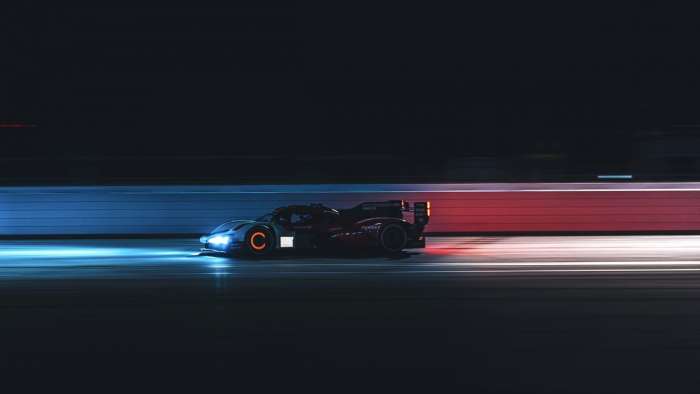 Image of the Porsche 963 during night testing at Daytona with its front brake disc glowing red hot under heavy breaking.