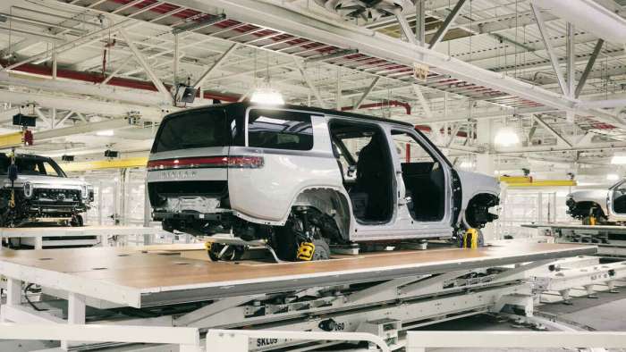 An image showing a partially assembled Rivian R1S on a production line at a factory in Normal, Illinois.