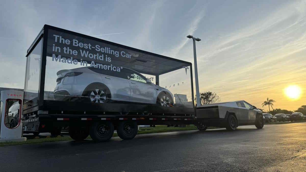 A Tesla Pulling a Tesla: Advertising In Glass Display On Truck Bed: Mobile Advertising of Tesla At Its Finest