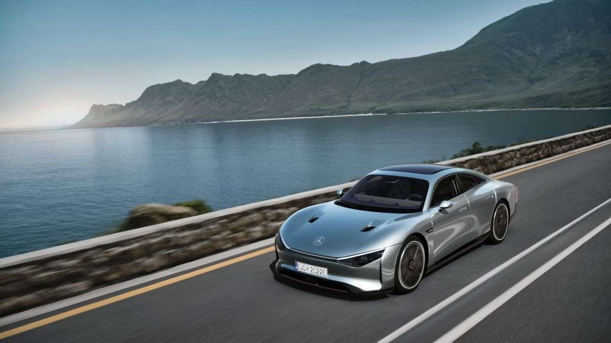 Image showing a rendering of a silver Mercedes-Benz EQXX concept car driving beside a lake with mountains in the background.