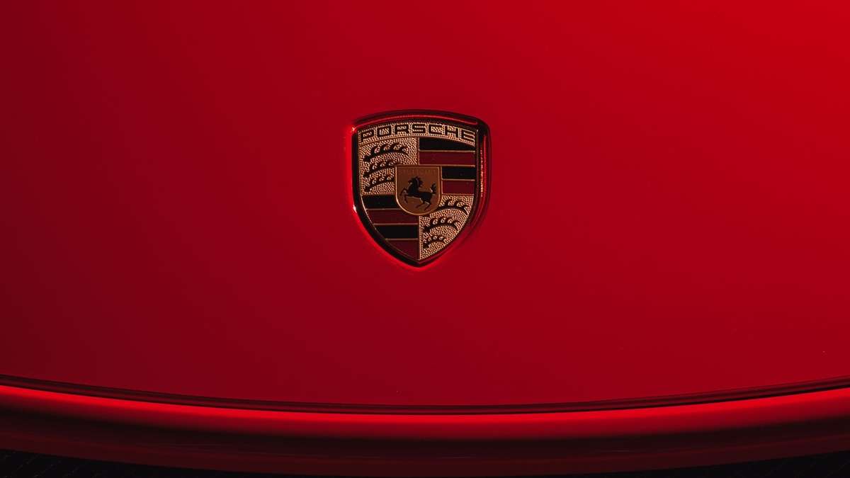 Image showing the Porsche crest on the hood of a red car.