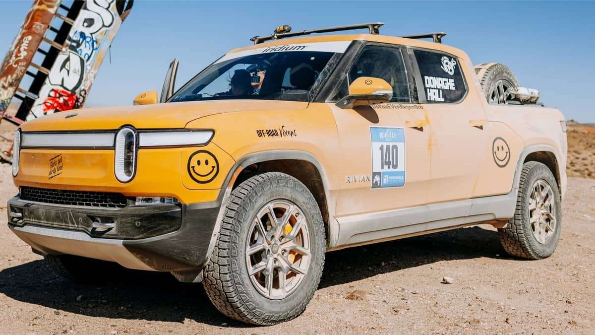 Yellow Rivian R1T shown covered in dust after competing in the 2021 Rebelle Rally.