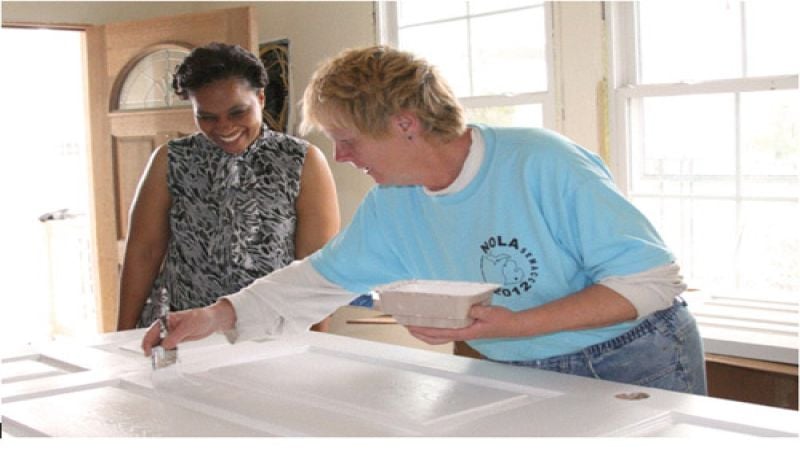 Home owner Courtenay LaRoche watches St. Bernard Project volunteer Sharon Jenks 