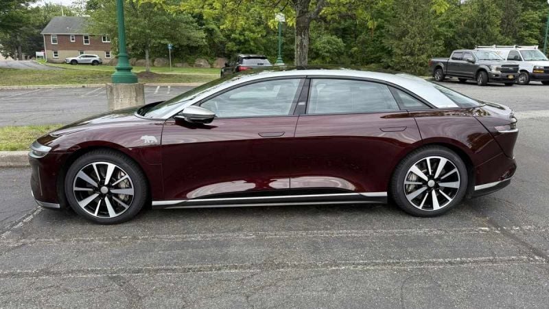 A 2022 red Lucid Air GT parked on asphalt, showcasing its modern design and distinctive alloy wheels.