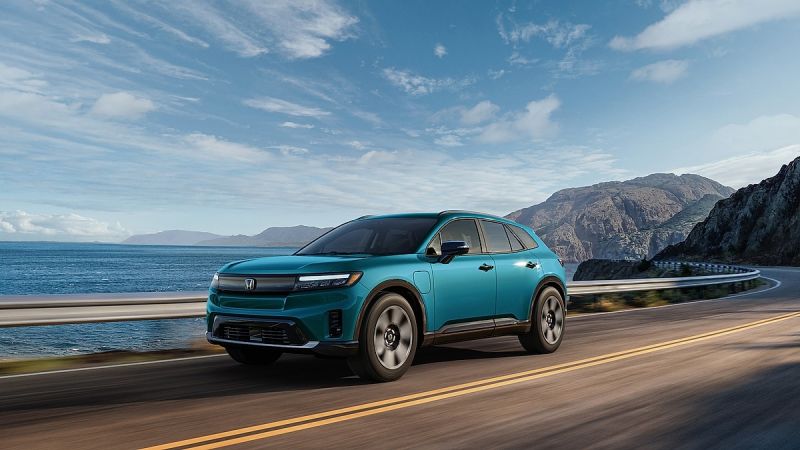 2024 Honda Prologue Elite electric SUV driving along a coastal highway