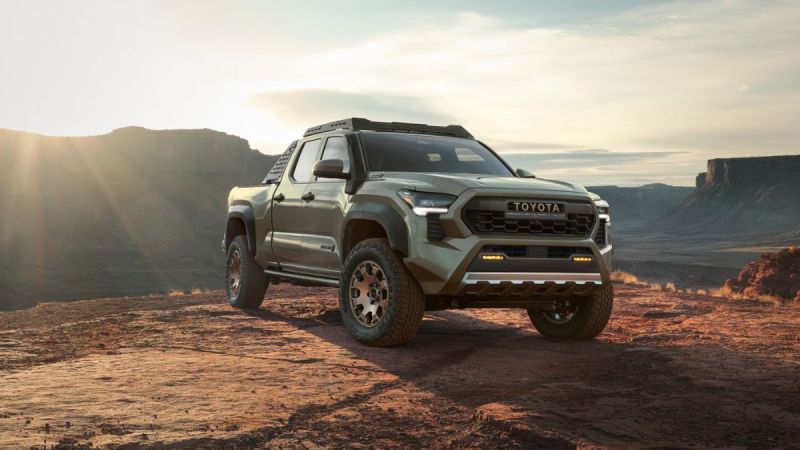 Sage green Toyota Tacoma TRD Off-Road truck parked on rocky terrain with dramatic canyon sunset backdrop