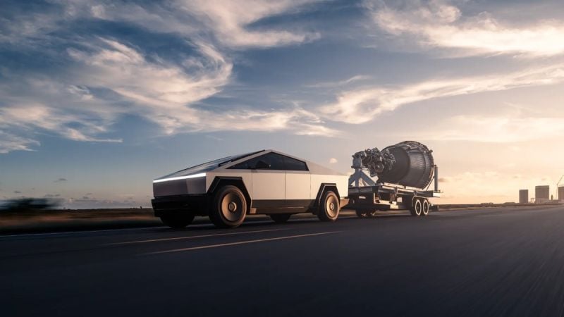 Tesla Cybertruck towing a large industrial turbine on a trailer while driving on an open highway at sunset.