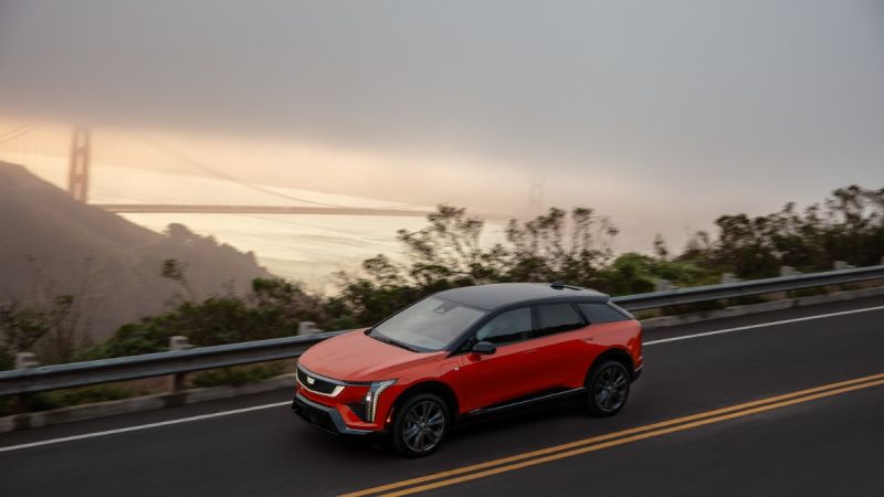 Red SUV driving on a road with the Golden Gate Bridge in the background.