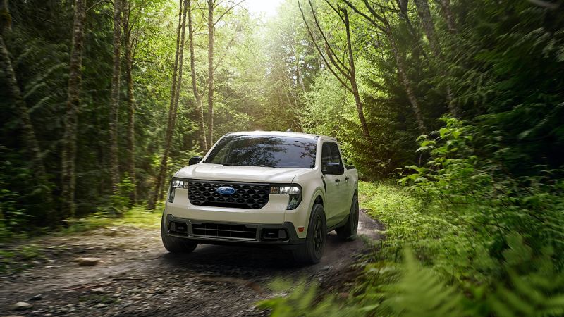 2025 Ford Maverick compact pickup driving on a forest trail, front three-quarter view