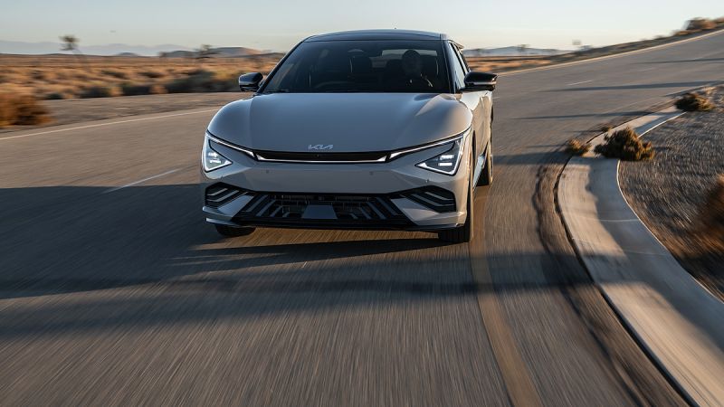 2025 Kia EV6 electric vehicle driving quickly along a desert road at sunset