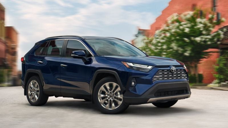 A 2025 Toyota RAV4 in blue metallic paint photographed from the front three-quarter view, emphasizing its athletic stance and contemporary design.
