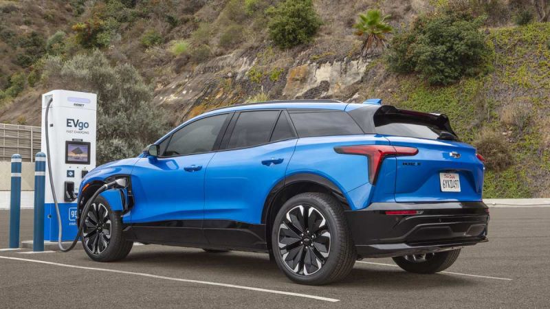 A blue 2026 Chevrolet Blazer EV is charging at an EVgo fast charging station amid a hilly landscape with greenery in the background.