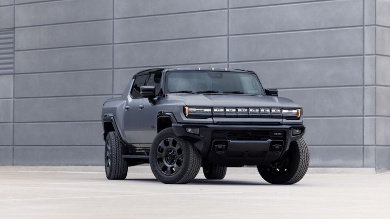 2026 GMC Hummer EV pickup front three-quarter view in matte gray with bold grille and rugged off-road stance