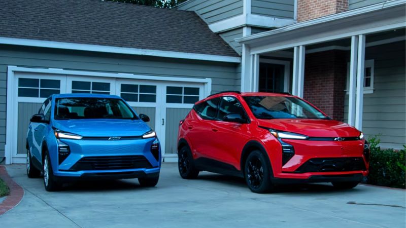2027 Chevrolet Bolt EV, two of them, blue and red, parked in front of house