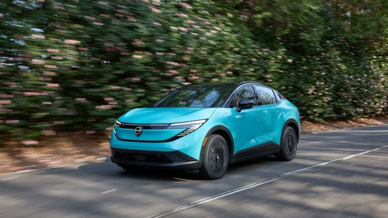 2026 Nissan Leaf in blue shown driving quickly in a forested area