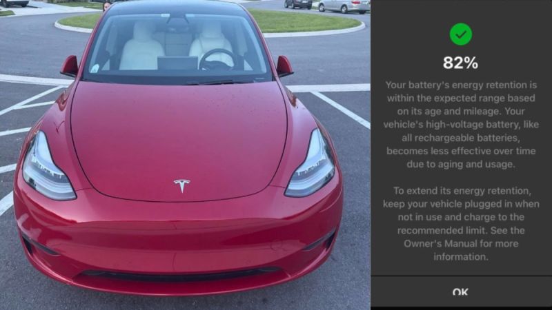 Candy red Tesla Model 3 parked head-on, sleek electric sedan with minimalist front design in parking lot
