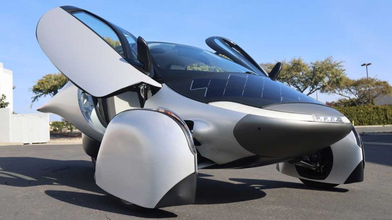 Image of the front of the Aptera, showcasing it's Lambo style doors, and solar panels on nose