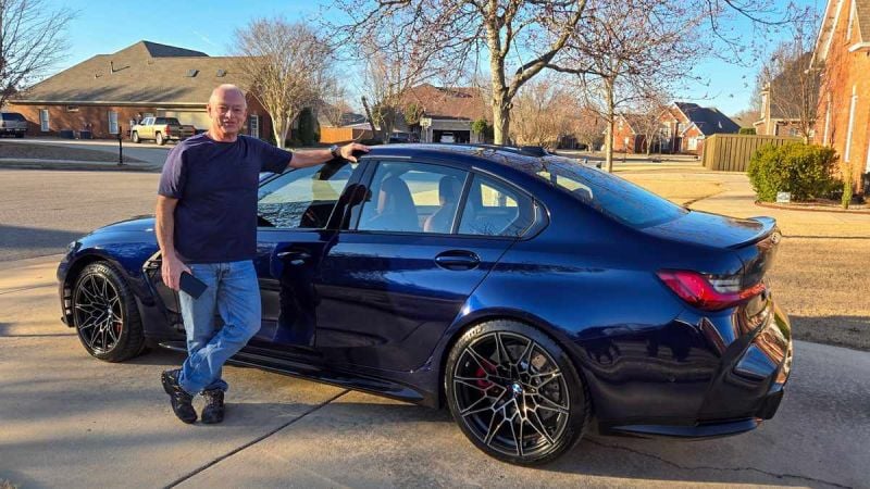 Blue BMW M3 with man standing next to it