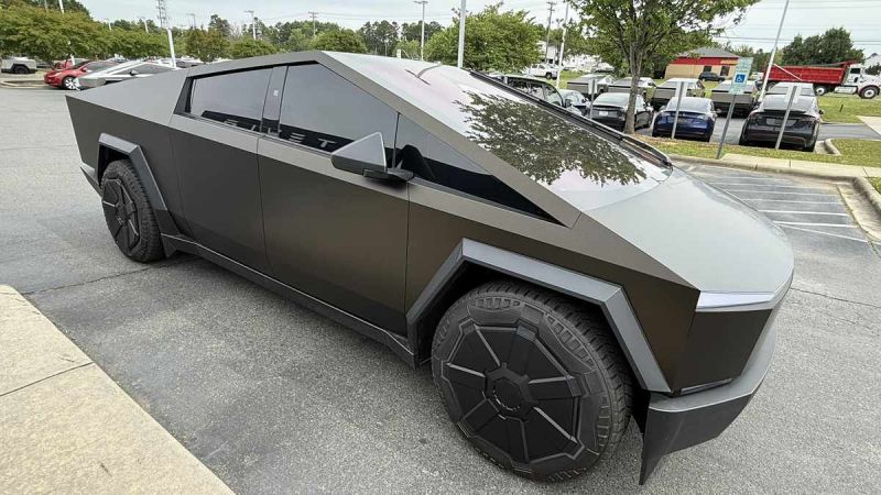 A bronze, 2025 Tesla Cybertruck parked in a lot, showcasing its futuristic design and unique geometric features.