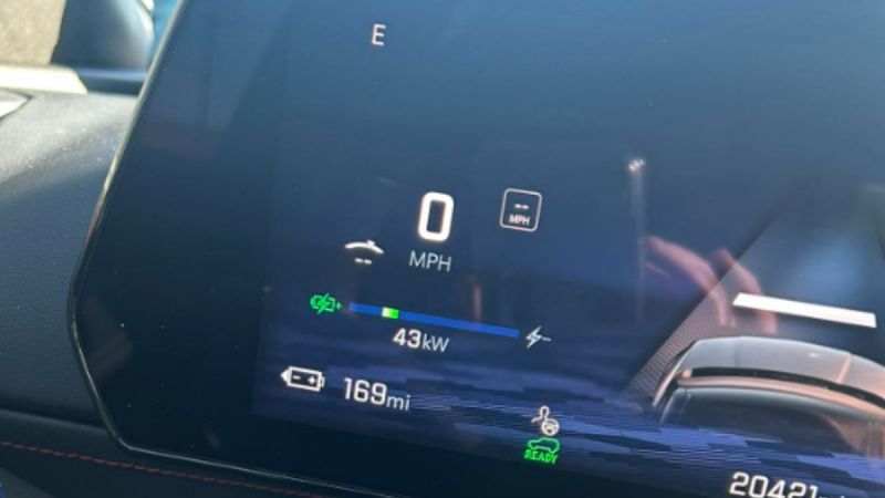 Digital instrument cluster display showing 0 MPH, 43kW power output, 165 miles of remaining range, and various indicator lights on a dark blue background.