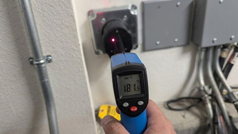 Infrared thermometer measuring 181 degrees on EV charger outlet showing heat buildup