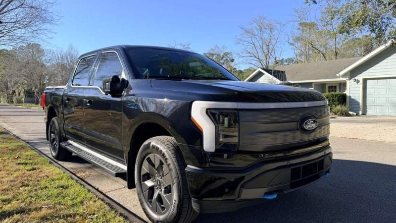 Ford F-150 Lightning electric pickup truck parked on a residential street, front three-quarter view