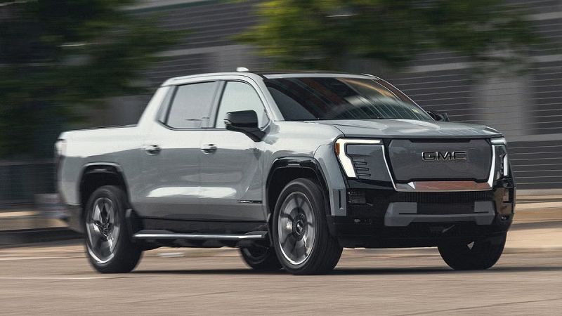 GMC Sierra EV electric pickup truck driving at speed with motion blur showing side profile