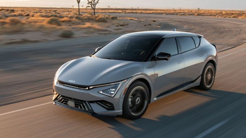 A gray 2025 Kia EV6 in a desert landscape, showcasing its aerodynamic design and advanced features on an open road.