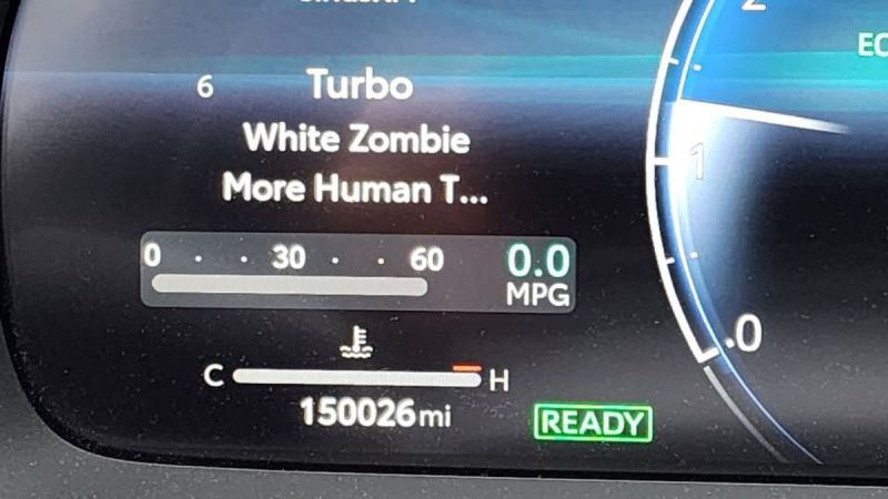 Digital instrument cluster display showing 150,026 miles with drive mode options visible, along with MPG and temperature gauges in a modern blue-lit interface.