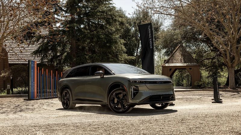 Lucid Gravity SUV parked outdoors at event with trees and buildings