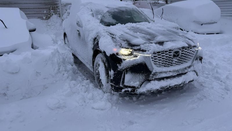 Mazda CX-90 covered in snow after winter storm, demonstrating AWD capability in deep snow