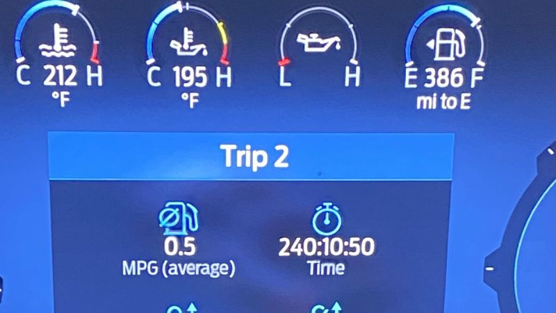 Ford F-150 dashboard display showing Trip 2 statistics including fuel economy of 0.5 MPG average and trip time of 240:10:50, with temperature and fuel level indicators visible at the top of the blue digital interface.