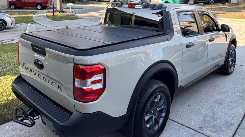 Shawn's 2025 Ford Maverick pickup truck shown from the rear quarter view, featuring a black tonneau cover over the bed and distinctive taillights.