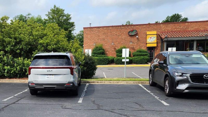 The 2025 Kia Carnival Hybrid SX Prestige parked at a parking lot next to a Mazda