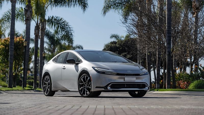 Toyota Prius Prime parked on street with palm trees and sunny background