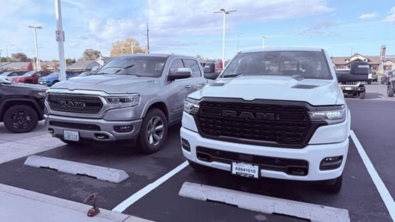 Two parked RAM 1500 trucks in a dealership lot on a clear day. One is silver and the other is white. Their bold grilles and large frames convey strength.